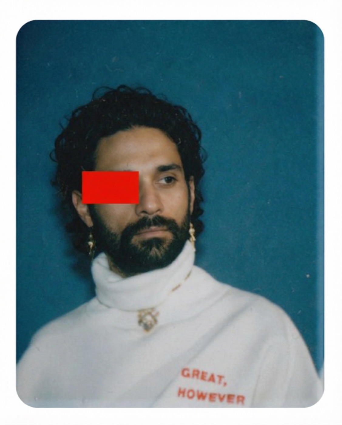 Amos Le Blanc editorial portrait in a white turtleneck with a red bar across one eye